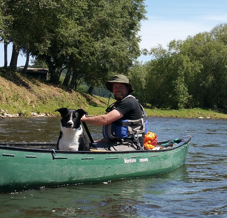 A photograph of a man in his canoe
