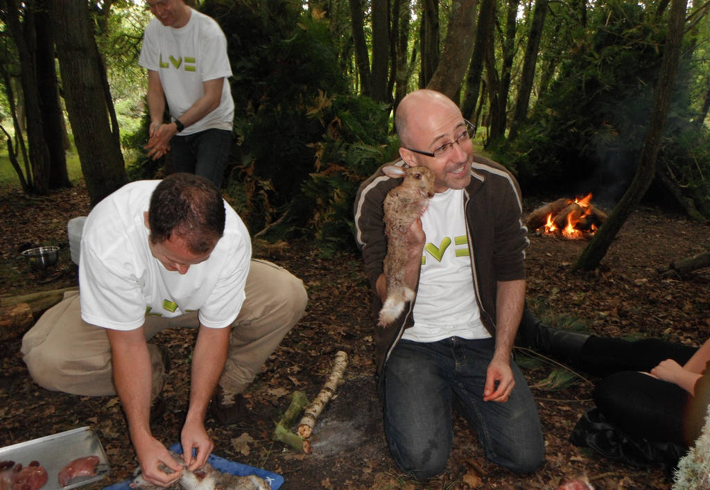 A corporate group preparing rabbit in the woods