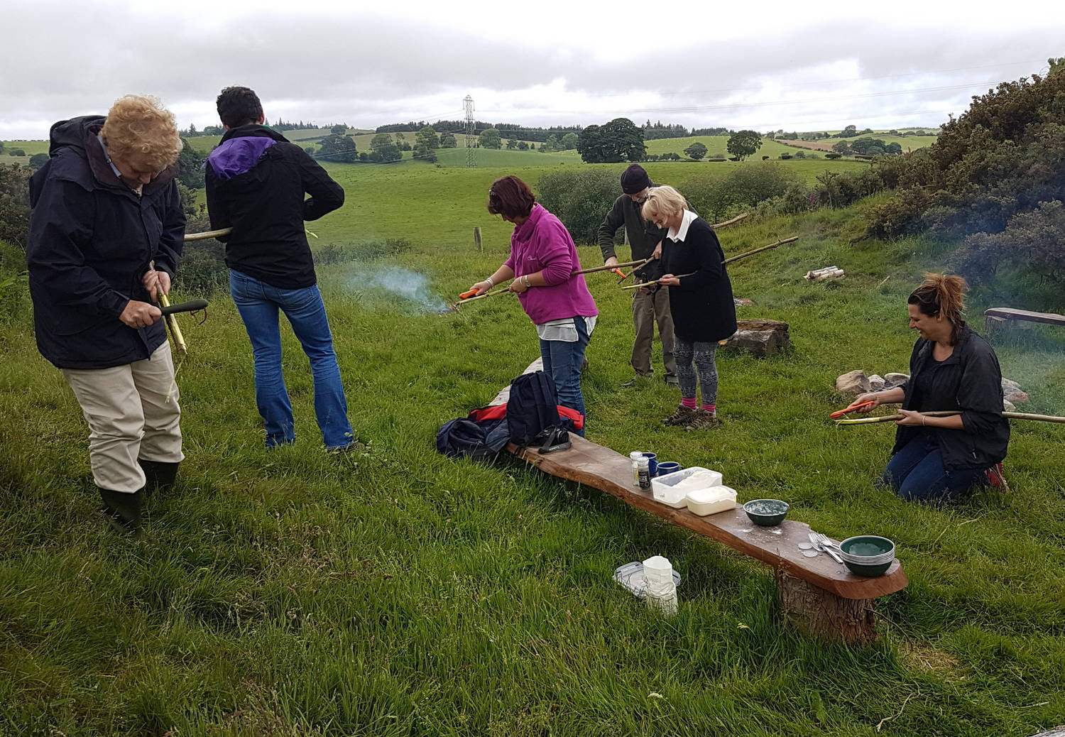 People gathered around in a field eating