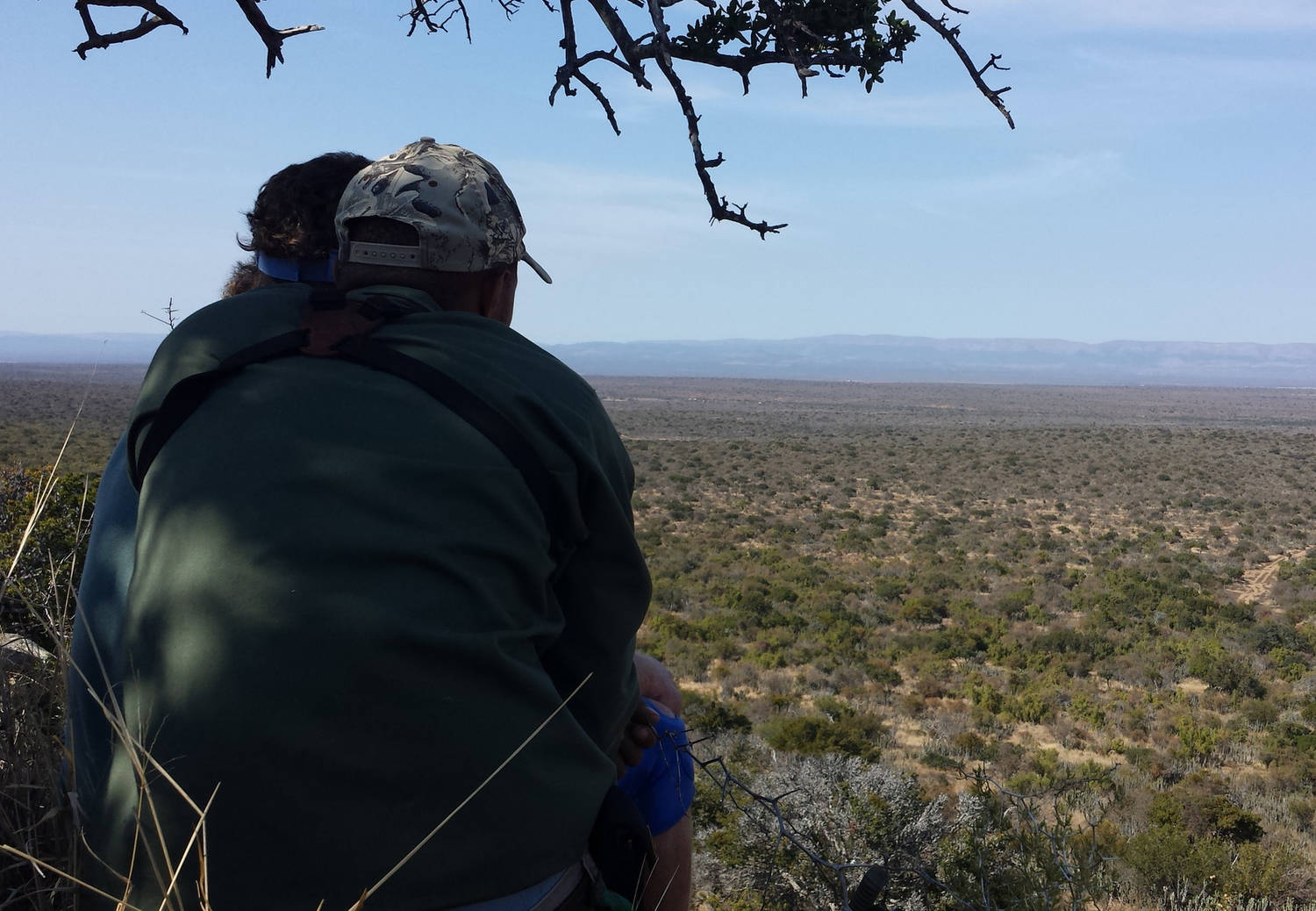 A photograph of two people looking out onto South Africa's landscape